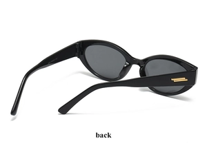 Vue détaillée des lunettes de soleil œil de chat noires montrant les accents dorés des branches