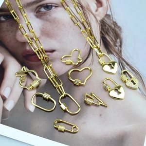 Détail de pendentifs coeur et papillon en zircone dorée sur un magazine de mode