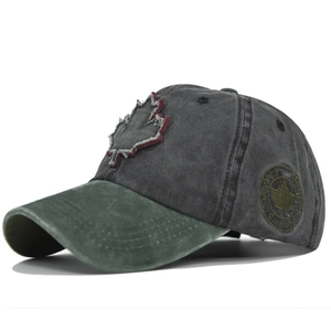Detail of vintage washed cotton baseball cap with maple leaf embroidery and distressed brim