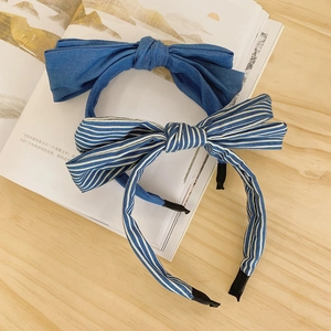 Detail of double-layered bow headbands in navy blue and striped denim fabric