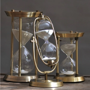 Macro shot of vintage brass metal hourglass frames with fine white sand and glass details