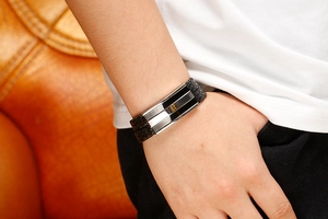 Close-up of men's double-layered black braided leather bracelet with metal accents