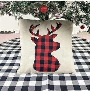 Close-up of linen Christmas pillow cover with red and black buffalo plaid reindeer motif