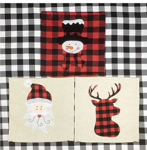 Detail of Christmas pillow covers featuring Santa and reindeer on red plaid fabric