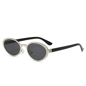 Vintage oval silver metal sunglasses with textured frame and dark grey lenses for women