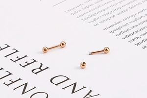 Détail du fermoir à vis des boucles d'oreilles boules or rose et structure filetée