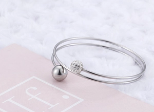 Detailed macro view of silver double-layer steel bracelet with crystal bead decoration