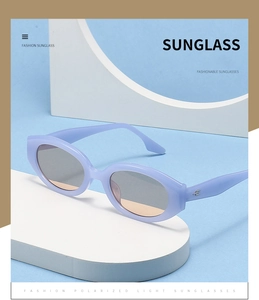 Detail of lavender oval sunglasses featuring silver hinge accents on a white stand