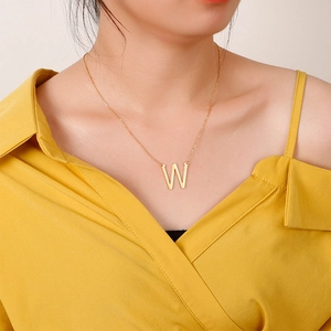 Collier doré en acier inoxydable avec pendentif lettre W porté sur un modèle