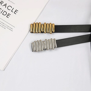 Detail of minimalist thin leather belts with gold and silver caterpillar metal buckles