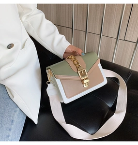 Detail of color-block crossbody bag in green, khaki, and white with gold chain and wide strap