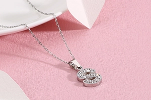 Gros plan d'un collier argenté avec pendentif lettre S serti de cristaux étincelants