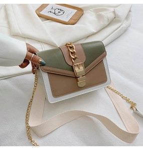 Detail of green and khaki tricolor shoulder bag with gold chain and wide fabric strap