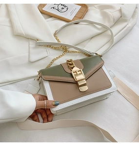 Detail view of the green and white patchwork PU leather handbag with gold buckle and chain