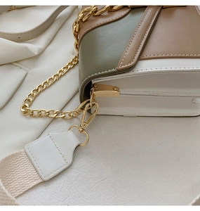 Detail of color-block PU leather bag with gold chain and woven shoulder strap