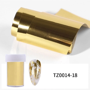 Macro view of metallic gold nail foil roll and decorative flakes for DIY nail art
