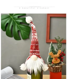 Detail of Nordic gnome wine bottle cover with red knitted hat and white faux fur beard