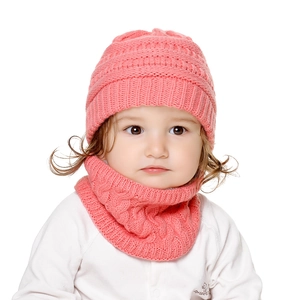 Details der Stricktextur von korallenrosa Babymütze und gefüttertem Schal für Winter