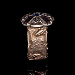 Dettaglio anello punk vintage con zaffiro blu e rilievi di foglie in oro rosa