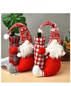 Close-up of knit Christmas gnome wine bottle covers with red and grey plaid patterns