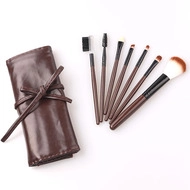 Deep brown 7-piece makeup brush set with leather roll-up storage case on white background