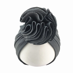 Detail of dark grey waffle fabric baby turban hat with a large 3D sunflower decoration