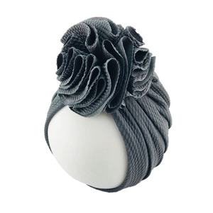 Detail of dark grey waffle knit baby turban hat with a large layered flower ornament
