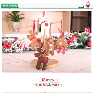 Detail view of felt Christmas reindeer and gingerbread man ornaments on a wooden stand