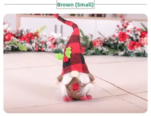 Close-up of small brown Christmas gnome with red plaid hat and snowflake detail