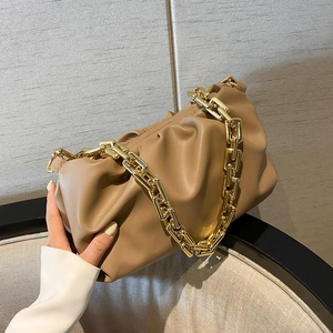 Detail of khaki soft cloud bag featuring a chunky gold metal chain strap and pleats