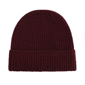 Close-up of deep red ribbed knit texture on a warm winter beanie hat with cuff