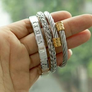 Detailed shot of three-piece silver and gold crown bangles with Roman numerals