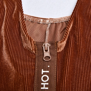 Détail du tissu en velours côtelé marron et fermeture éclair avec imprimé HOT décoratif