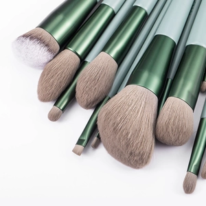 Set of 13 professional makeup brushes with green wooden handles and soft brown bristles