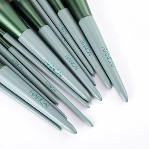 Close-up of mint green makeup brushes with dark green metal ferrules and wood handles