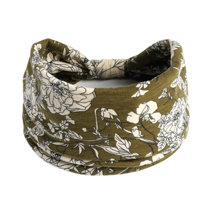 Détail d'un bandeau élastique vert olive avec motifs floraux blancs et texture