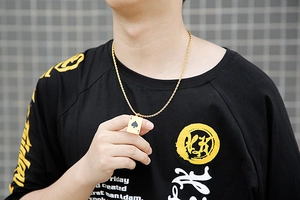 Golden Ace of Spades pendant with cubic zirconia on a twist chain worn by model