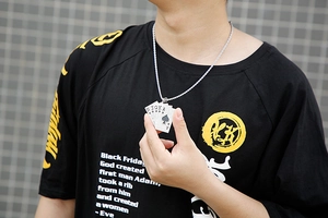 Close-up of hip hop pendant with silver ace of spades poker cards and pavé zircon stones