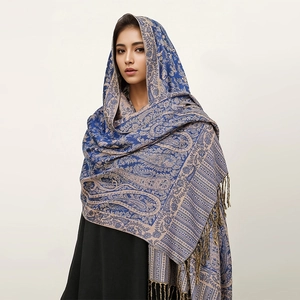 Detail of blue and beige paisley pattern cashmere feel shawl with tassel fringe edges