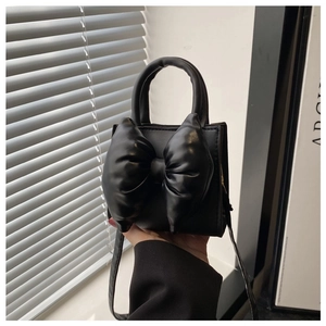 Close-up of black PU leather handbag with a prominent 3D bow and elegant round handle