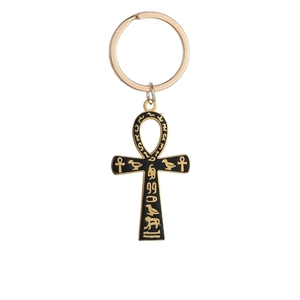 Close-up of golden and black Ankh cross keychain with engraved ancient Egyptian symbols