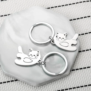 Cute stainless steel cat couple keychains set on a minimalist marble display pad