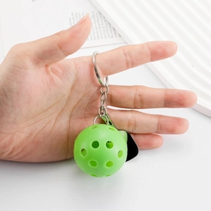 Green pickleball keychain with metal ring held by hand, ideal for sports event gifts