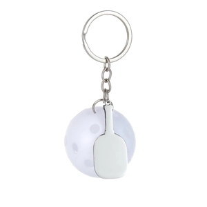Close-up of white pickleball and silver metal paddle keychain pendant on white background