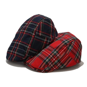 Close-up of red and navy plaid beret hats showing classic Scottish tartan fabric texture