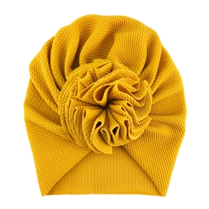 Mustard yellow baby turban hat with textured knit fabric and 3D floral decoration