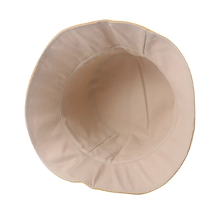 Dettaglio del cappello da sole giallo con fodera beige e cuciture rinforzate sull'orlo