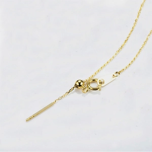 Macro view of gold stainless steel adjustable chain with slider bead and needle end