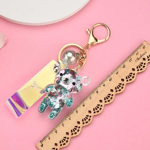 Detailed view of Rilakkuma oil-filled liquid keychain with iridescent strap and scale reference