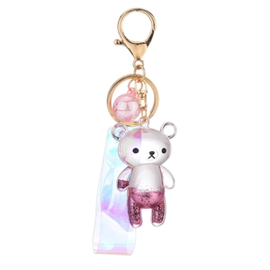 Glitter bear keychain with pink quicksand liquid and holographic strap on white background